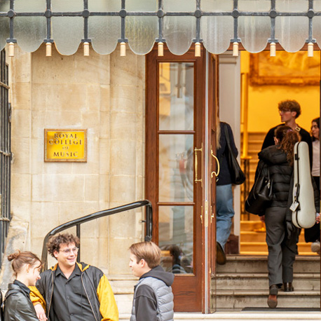 A building entrance with students chatting near the entrance, with the entrance stating "Royal College of Music"